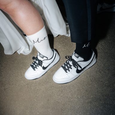 bride and groom wearing matching black and white nikes